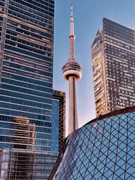 CN Tower rising between office buildings in downtown Toronto